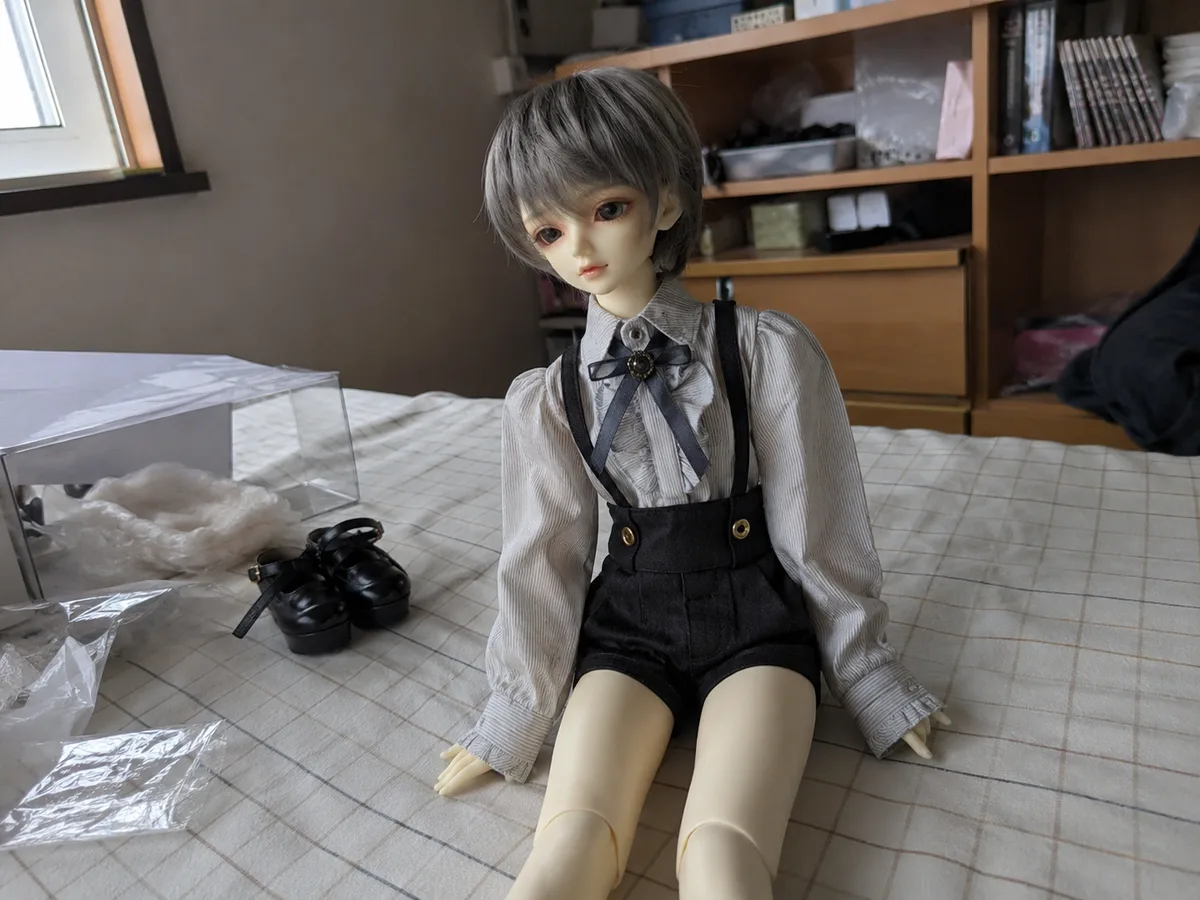 First fullset assembled: A finished BJD fullset photographed casually on a bed with packing materials still nearby.