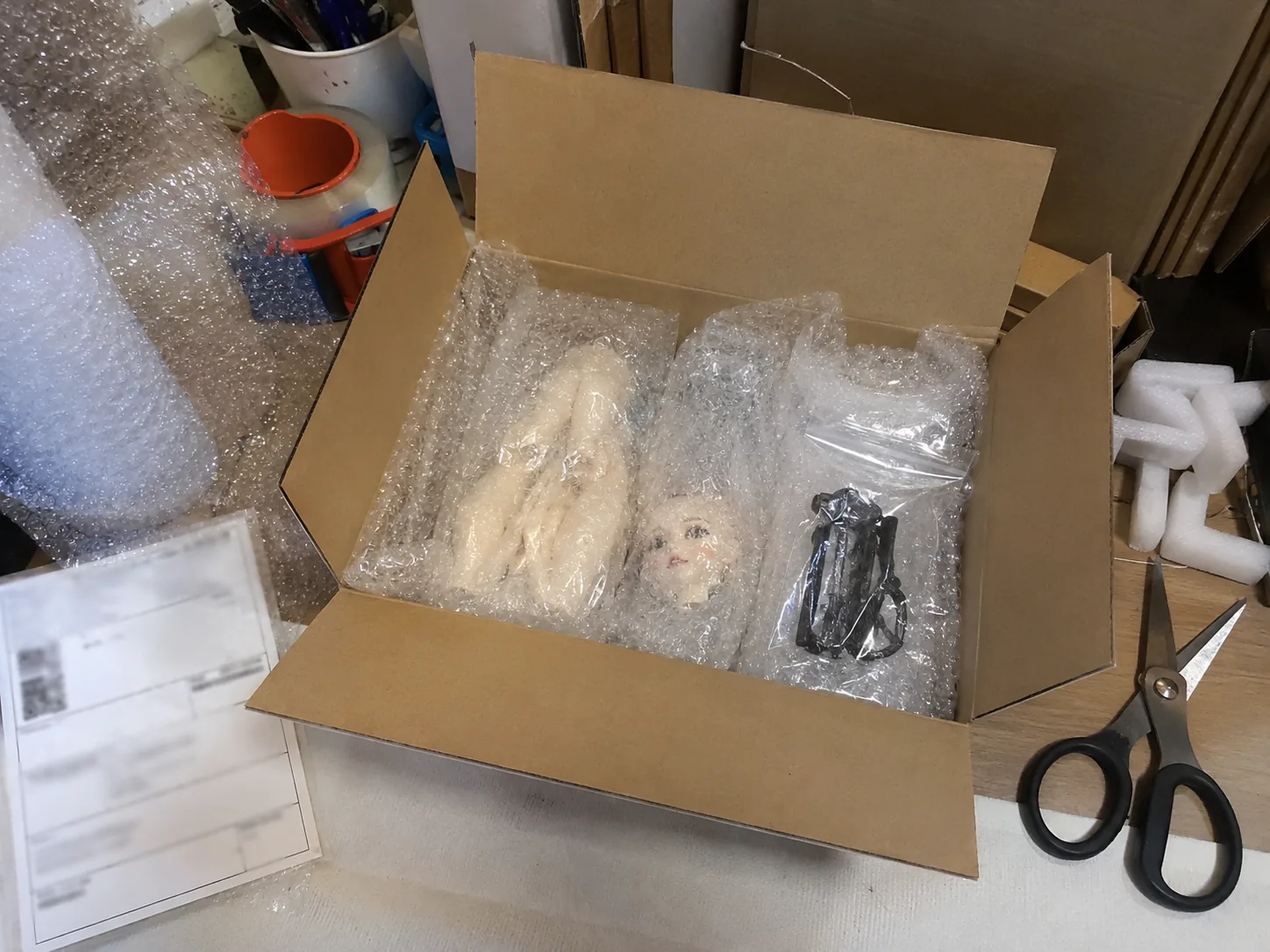 BJD parcel with blurred tracking label before sealing